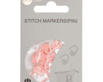 May include: A package of pink stitch markers (pin) for knitting and crochet. The package is gray with the text "STITCH MARKERS(PIN)" and the brand name "Tulip". The markers are heart-shaped and made of plastic.
