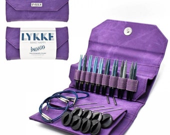 May include: A purple Lykke Indigo interchangeable circular knitting needle set. The set includes needles in various shades of blue and gray, cables, and black stitch markers. The set is contained in a purple fabric case with the Lykke logo.