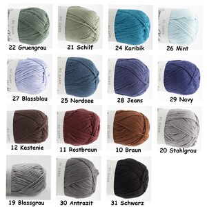 Puede incluir: Una colecci&oacute;n de 12 ovillos de lana en varios colores, incluyendo verde, azul, marr&oacute;n, gris y negro. Cada ovillo est&aacute; etiquetado con un n&uacute;mero y un nombre de color en alem&aacute;n.