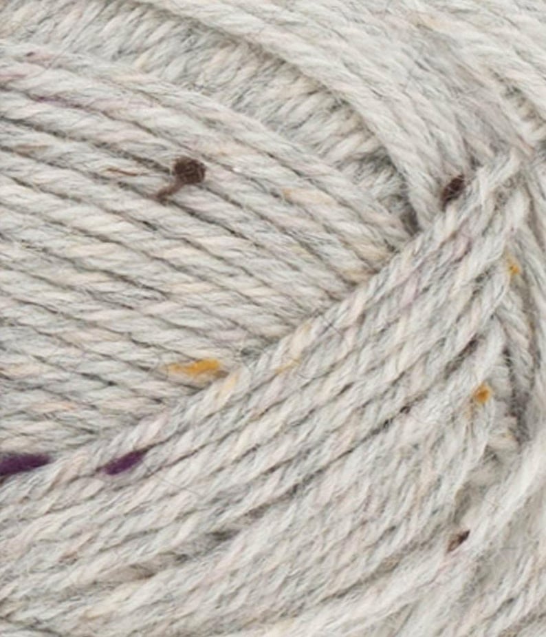 May include: A skein of light gray yarn with flecks of brown, purple, and yellow. The yarn is made of wool and is suitable for knitting or crocheting.