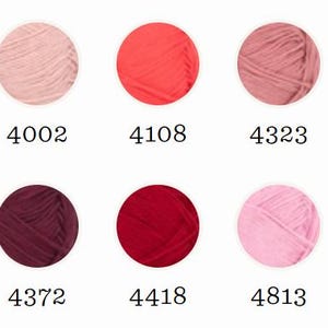 May include: A selection of ten yarn skeins in various shades of red, pink, and purple. Each skein is a circular shape with a unique color and a corresponding number. Two skeins are labeled "NEW".