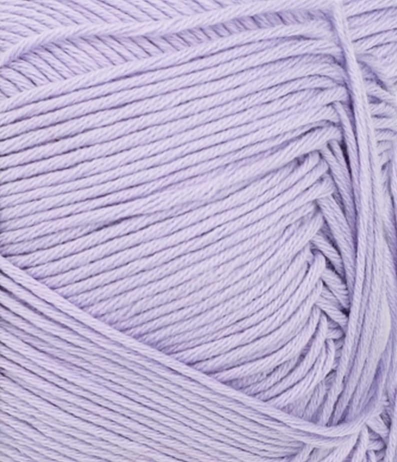 May include: A close-up of a ball of light purple yarn. The yarn is tightly wound, showing individual strands with a slight sheen. The color is a soft, pastel lavender, ideal for knitting or crocheting projects.