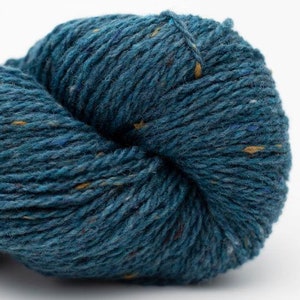 May include: A skein of teal blue yarn with flecks of yellow and brown.