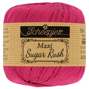 Puede incluir: Una madeja de hilo rosa Scheepjes Maxi Sugar Rush. La etiqueta dice "Scheepjes Maxi Sugar Rush" e incluye informaci&oacute;n sobre el peso y el calibre del hilo.
