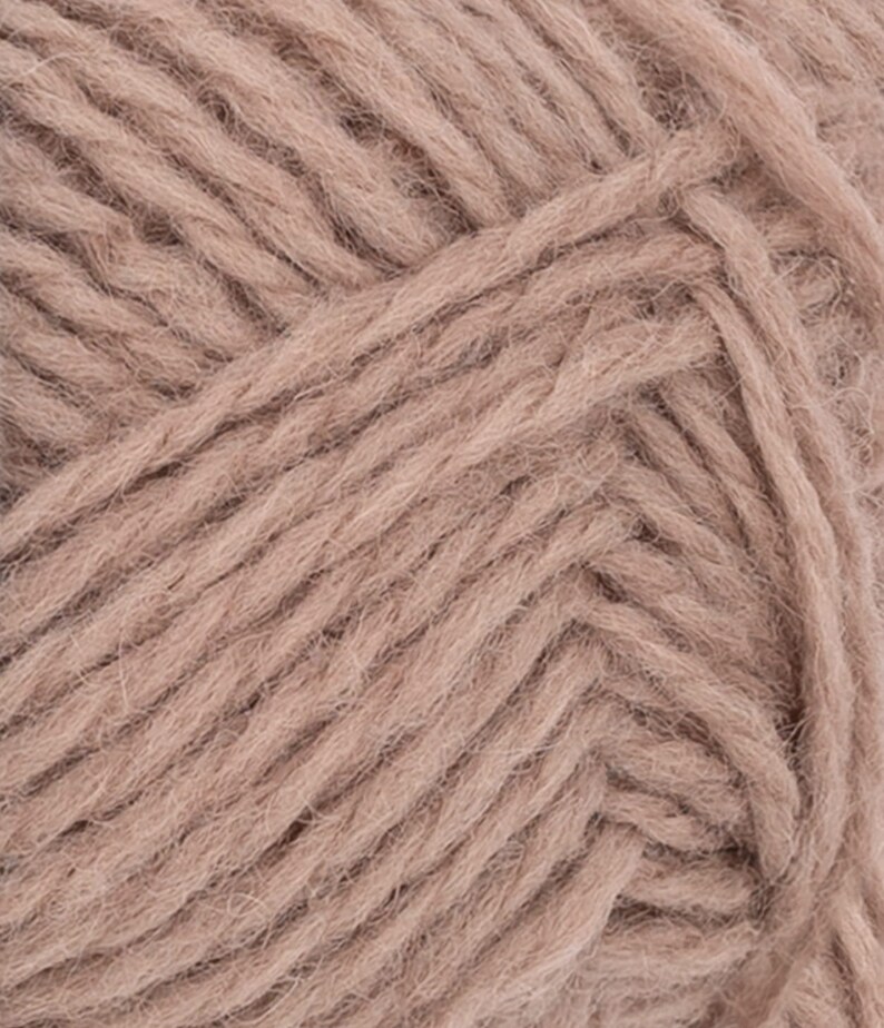 May include: A close-up view of dusty rose colored yarn, showing the twisted fiber strands and the soft, fuzzy texture of the material. The individual plies are clearly visible, creating a dense, uniform pattern across the entire surface.