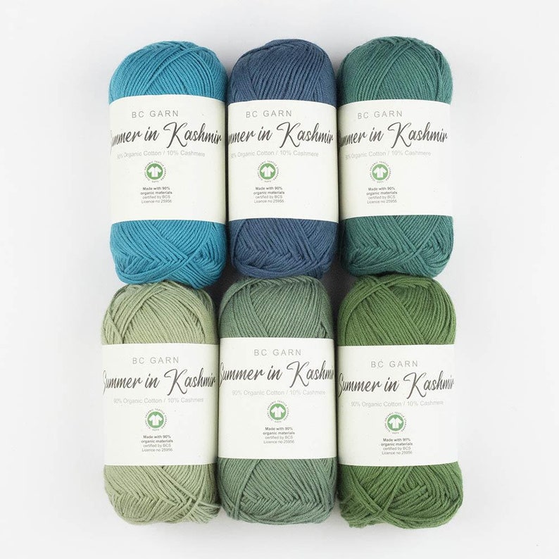 Puede incluir: Seis ovillos de lana en varios tonos de verde y azul. La lana est&aacute; etiquetada como "BC Garn Summer in Kashmir 90% Organic Cotton/10% Cashmere".