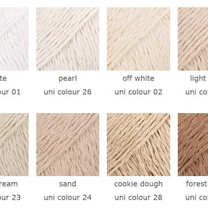 May include: A collection of eight yarn samples in various neutral colors, including white, pearl, off-white, light beige, mint cream, sand, cookie dough, and forest brown. Each sample is labeled with its color name and a corresponding "uni colour" number.