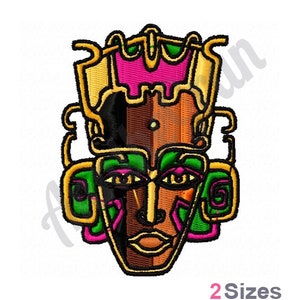 May include: A colorful, stylized mask with geometric patterns in shades of green, pink, brown, and gold. The mask has a human-like face with large eyes and a prominent nose.