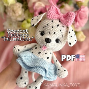 May include: A handmade crochet Dalmatian dog with black spots, a pink bow, and a blue skirt. The text "Crochet Pattern 'Dalmatian'" is visible. The PDF pattern is available.