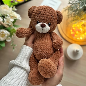Puede incluir: Un oso de peluche de ganchillo marr&oacute;n con hocico blanco y ojos negros. El oso es suave y afelpado, con una superficie texturizada. Es un juguete tierno, perfecto para un ni&ntilde;o o como objeto decorativo.