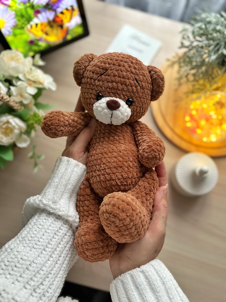 Puede incluir: Un oso de peluche de ganchillo marr&oacute;n con hocico blanco y ojos negros. El oso es suave y afelpado, con una superficie texturizada. Es un juguete tierno, perfecto para un ni&ntilde;o o como objeto decorativo.