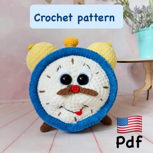 May include: A whimsical crochet clock pattern with a smiling face, blue trim, and yellow accents. The clock face is white with black eyes, a brown mustache, and a red mouth. The text "Crochet pattern" is displayed above the clock.