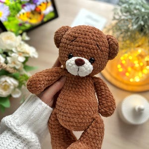 Puede incluir: Un oso de peluche marr&oacute;n hecho a mano con hocico blanco y ojos oscuros. El juguete de peluche est&aacute; hecho de un material suave y texturizado y tiene un dise&ntilde;o cl&aacute;sico de oso de peluche. El oso mide aproximadamente 20 cm de alto, perfecto para un juguete infantil o decoraci&oacute;n de guarder&iacute;a.