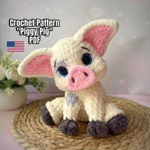 May include: A crocheted piglet with cream-colored yarn, pink inner ears, and a pink snout. The piglet has blue eyes and gray accents on its legs. The text "Crochet Pattern "Piggy Pig" PDF" is displayed above the piglet, with the American flag.