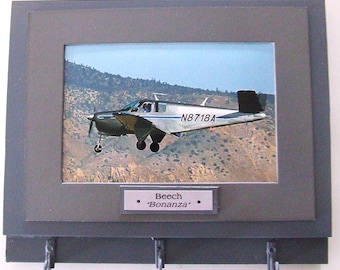 Wall Mounted Keychain Rack with a 4"X6" print of a Beechcraft Bonanza civilian aircraft.  Mounting screws are included.