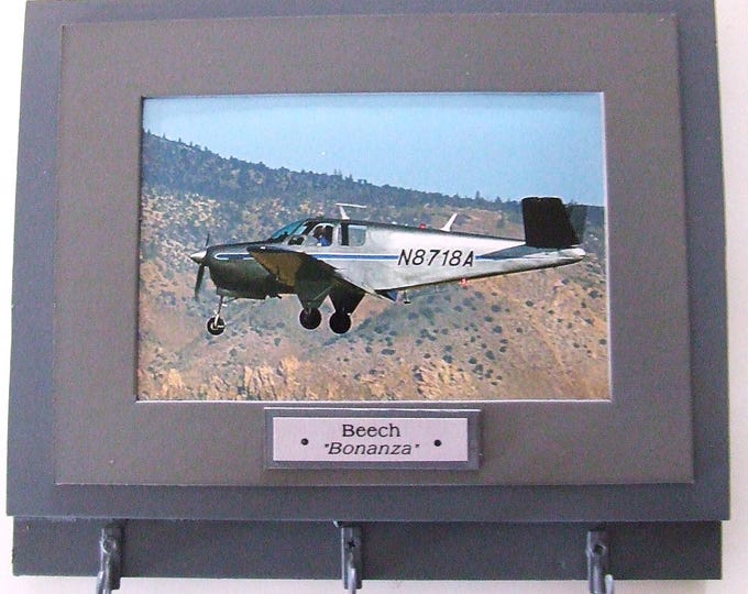 Wall Mounted Keychain Rack with a 4"X6" print of a Beechcraft Bonanza civilian aircraft.  Mounting screws are included.
