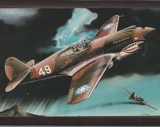 Framed 4" X 6" painting of a Curtiss P-40B "Flying Tigers" aircraft over China. Designed to hang on a wall or to display on a shelf or desk.