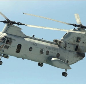 May include: A gray military helicopter with the words "MARINES" and "HMX-1" printed on the side. The helicopter has a tail number of "64713".