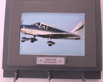 Wall Mounted Keychain Rack with a 4"X6" print of a Piper PA28 Cherokee civilian aircraft.  Mounting screws are included.