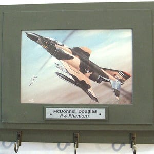 Wall Mounted Keychain Rack with a print of a painting of a McDonnell Douglas F-4 Phantom II shooting down a MiG over Vietnam.
