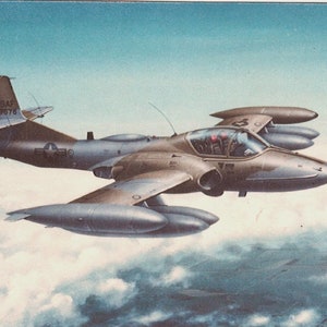 May include: A gray and brown military aircraft with the text "USAF 39678" on the side, flying over a cloudy sky.