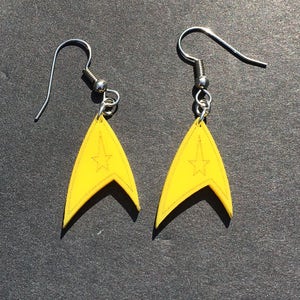 May include: A pair of yellow Star Trek insignia earrings with silver hooks.