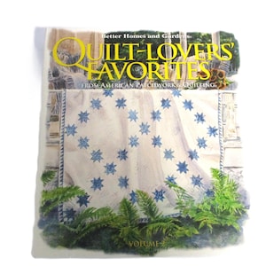 May include: A book titled "Quilt-Lovers Favorites" from American Patchwork & Quilting, volume 2. The cover features a blue and white quilt with a star pattern and green ferns.
