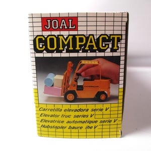 Może przedstawiać: Pudełko na zabawkę JOAL Compact. Pudełko przedstawia ż&oacute;łto-pomarańczowy w&oacute;zek widłowy podnoszący małe klocki. Na pudełku znajduje się napis "COMPACT" dużymi ż&oacute;łtymi literami. Pudełko zawiera r&oacute;wnież tekst w wielu językach.