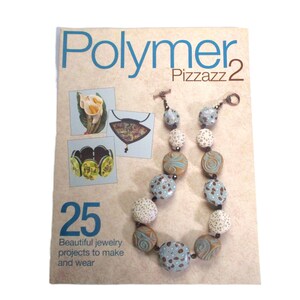 May include: A magazine cover featuring the title "Polymer Pizzazz 2" with a colorful necklace made of polymer clay beads. The cover also features the text "25 Beautiful jewelry projects to make and wear".