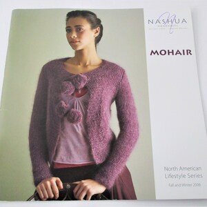 May include: A woman wearing a purple mohair cardigan with three decorative pom-poms. The image is from the "North American Lifestyle Series" for Fall and Winter 2006. The word "MOHAIR" is displayed in large letters.