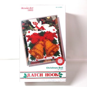 May include: A WonderArt Caron latch hook kit box featuring a Christmas Bell design. The box displays a finished 12 inch by 12 inch latch hook project with orange bells, red bows, and green foliage. Text includes WonderArt, Art. #4633, Quick & Easy, and LATCH HOOK.