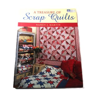 May include: A book titled "A Treasury of Scrap Quilts" by Nancy J. Martin. The cover features a room with a red and white quilt on the wall, a shelf with quilts, and a bed with a blue and white star quilt.