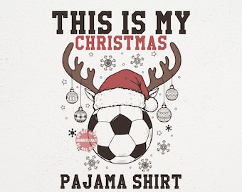 May include: A white graphic design featuring a soccer ball wearing a Santa hat and reindeer antlers. The text reads "THIS IS MY CHRISTMAS PAJAMA SHIRT". Decorative snowflakes and ornaments surround the central image.