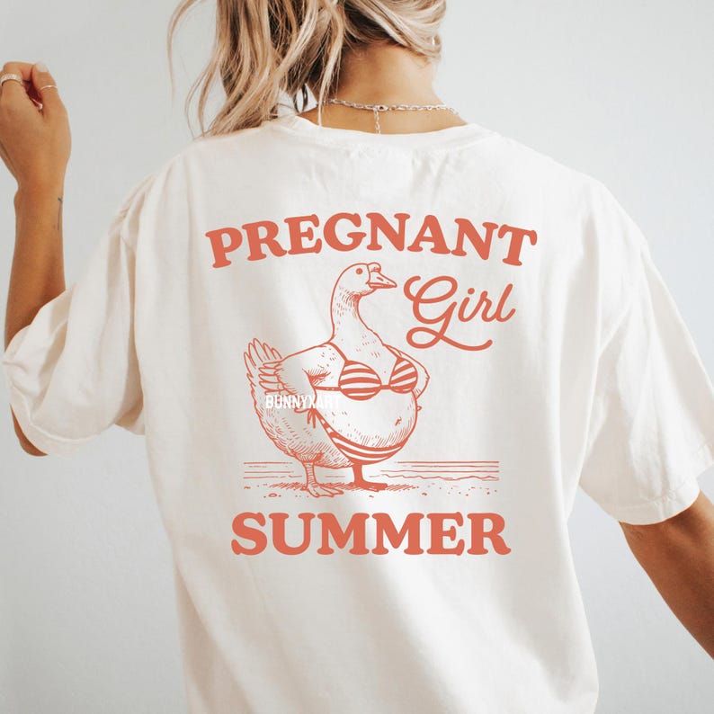 May include: White t-shirt with a red graphic of a pregnant duck wearing a bikini and the text "Pregnant Girl Summer".