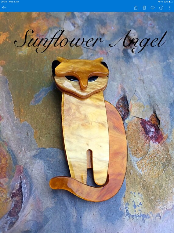 Art Deco 3D cat brooch. In golden shimmer, with black eyes and ears.