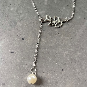 Branch and pearl slip Charm necklace, on a silver tone chain.