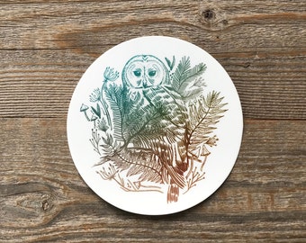 Może przedstawiać: Biały ceramiczny podkładka z zielono-brązową ilustracją sowy siedzącej w lesie z paprociami i grzybami.