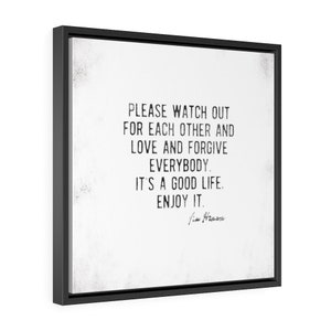 Op de afbeelding: Vierkante ingelijste wandkunst met een zwart frame. Het kunstwerk heeft een witte achtergrond met zwarte tekst die luidt: "PLEASE WATCH OUT FOR EACH OTHER AND LOVE AND FORGIVE EVERYBODY. IT'S A GOOD LIFE. ENJOY IT." Handtekening onderaan.