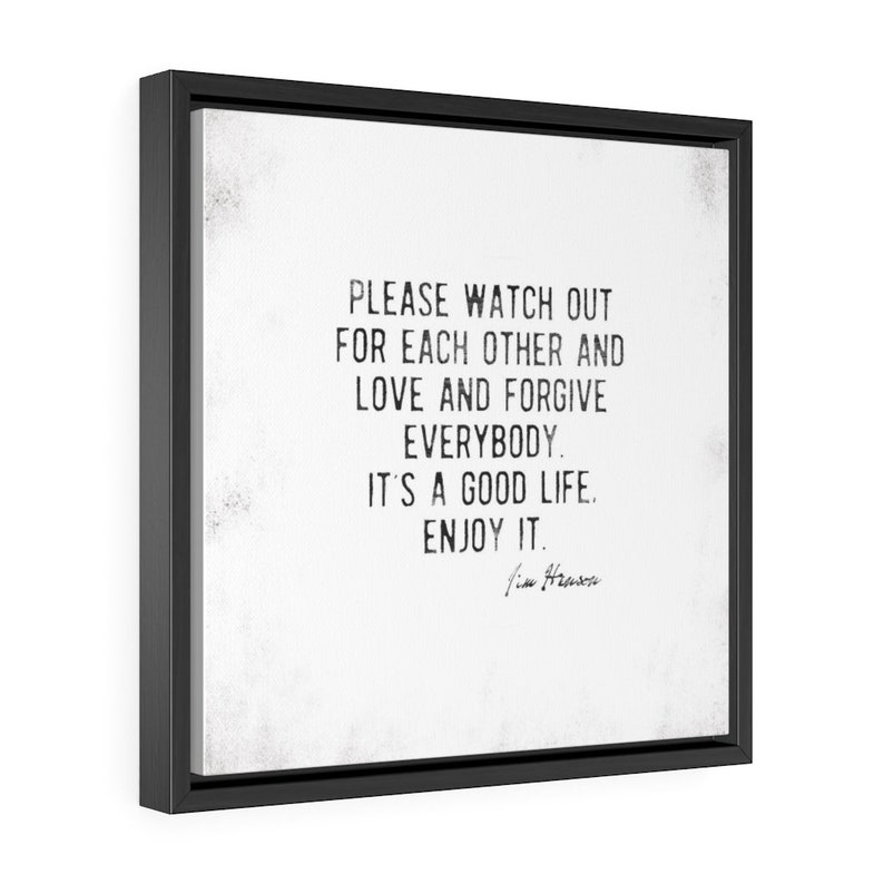Op de afbeelding: Een ingelijste canvas print met een zwart frame. De print toont de tekst "PLEASE WATCH OUT FOR EACH OTHER AND LOVE AND FORGIVE EVERYBODY. IT'S A GOOD LIFE. ENJOY IT." in zwarte letters op een witte achtergrond.