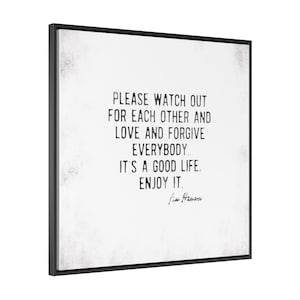 Op de afbeelding: Een ingelijste wandkunstprint met een zwart frame. Het kunstwerk heeft een witte achtergrond met zwarte tekst die luidt: "PLEASE WATCH OUT FOR EACH OTHER AND LOVE AND FORGIVE EVERYBODY. IT'S A GOOD LIFE. ENJOY IT." Handtekening onderaan.