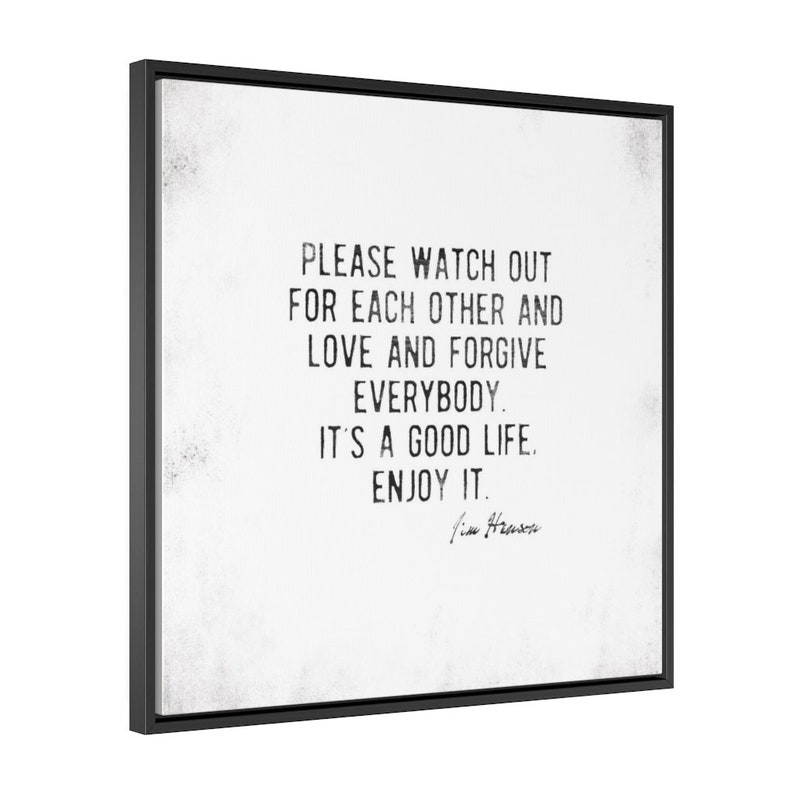 Op de afbeelding: Zwart omkaderde wandkunst met de tekst "PLEASE WATCH OUT FOR EACH OTHER AND LOVE AND FORGIVE EVERYBODY. IT'S A GOOD LIFE. ENJOY IT." in een zwarte, verweerde lettertype. Het kunstwerk is gesigneerd "Jim Henson".