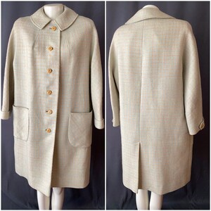 May include: A light green vintage coat with a rounded collar, wooden buttons, and two front pockets. The coat has long sleeves with turned-up cuffs. The coat is displayed on a mannequin. The coat measures approximately 40 inches in length.