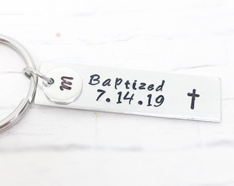 May include: Silver keyring with a small round charm engraved with the letter "M" and a rectangular tag engraved with "Baptized 7.14.19" and a cross.