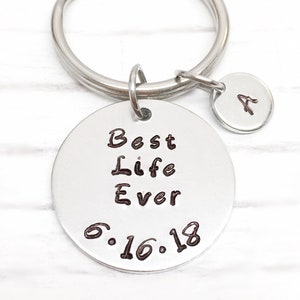 May include: Silver keychain with a round tag that says "Best Life Ever 6.16.18" and a smaller round tag with the letter "A" on it.