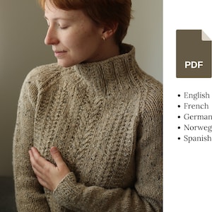 Op de afbeelding: Een bruine gebreide trui met een hoge hals en een textuurpatroon. De trui is gemaakt van een zacht, warm garen en heeft een ontspannen pasvorm.