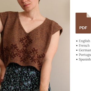 May include: A brown sleeveless knitted sweater with a geometric pattern. The sweater has a V-neck and is cropped. The sweater is being worn by a person.