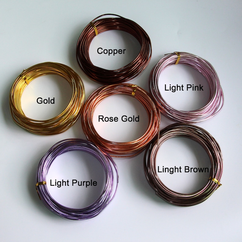 Op de afbeelding: Zes spoelen draad in verschillende kleuren: goud, koper, ros&eacute; goud, licht roze, licht paars en lichtbruin.