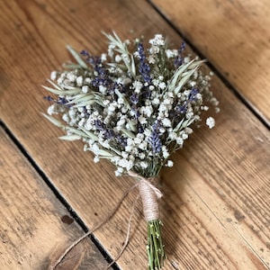Puede incluir: Un pequeño ramo de flores secas atado con cuerda. El ramo incluye aliento de bebé blanco, lavanda morada y hierbas secas.