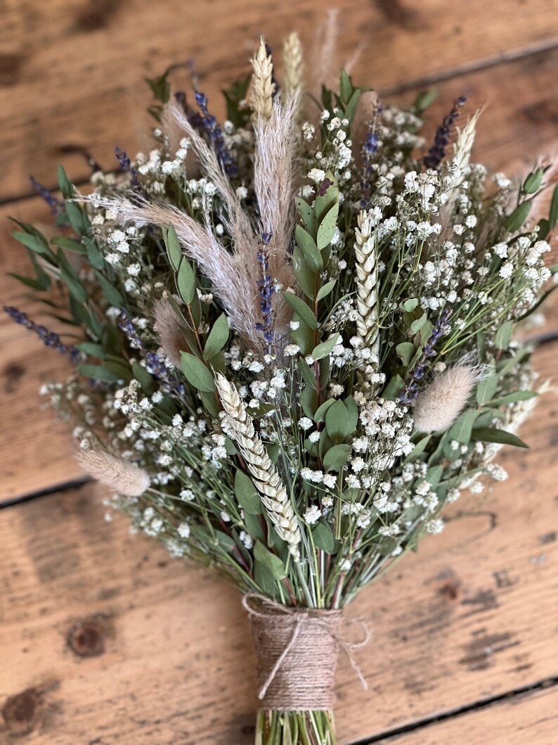 Puede incluir: Un ramo de flores secas con aliento de beb&eacute; blanco, trigo, lavanda y hierba de la pampa atado con cuerda.