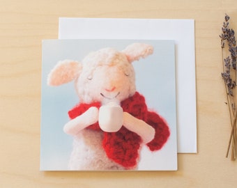 One square blank greeting card of sheep drink hot chocolate